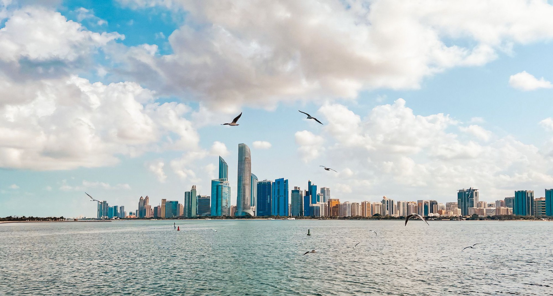 The Abu Dhabi skyline seen across the Gulf under a wide sky