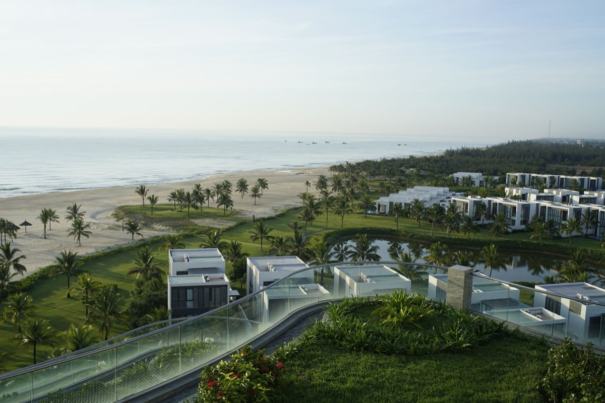 Low-rise residential buildings set behind a landscaped beachfront