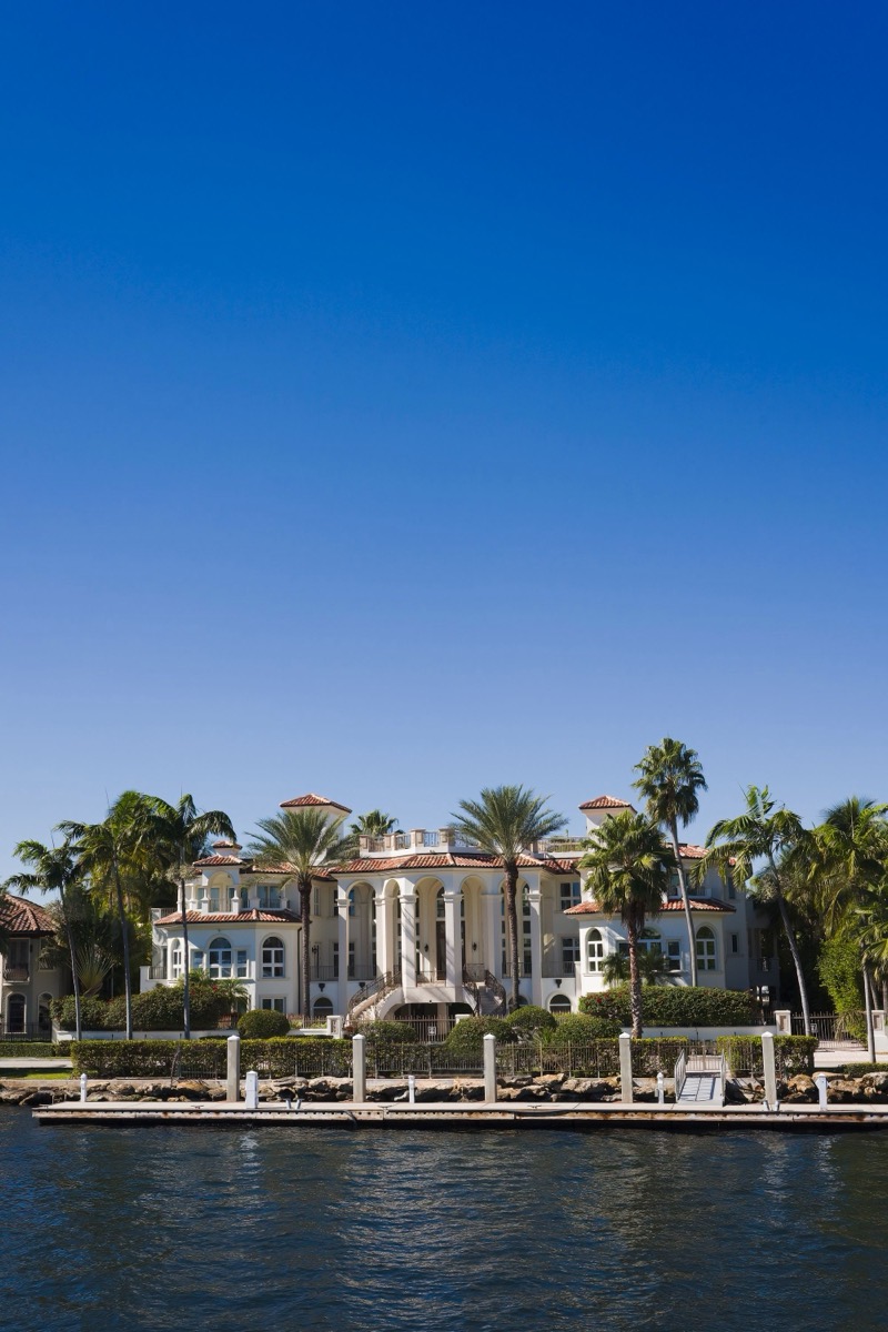 A large waterfront mansion with private mooring and palms