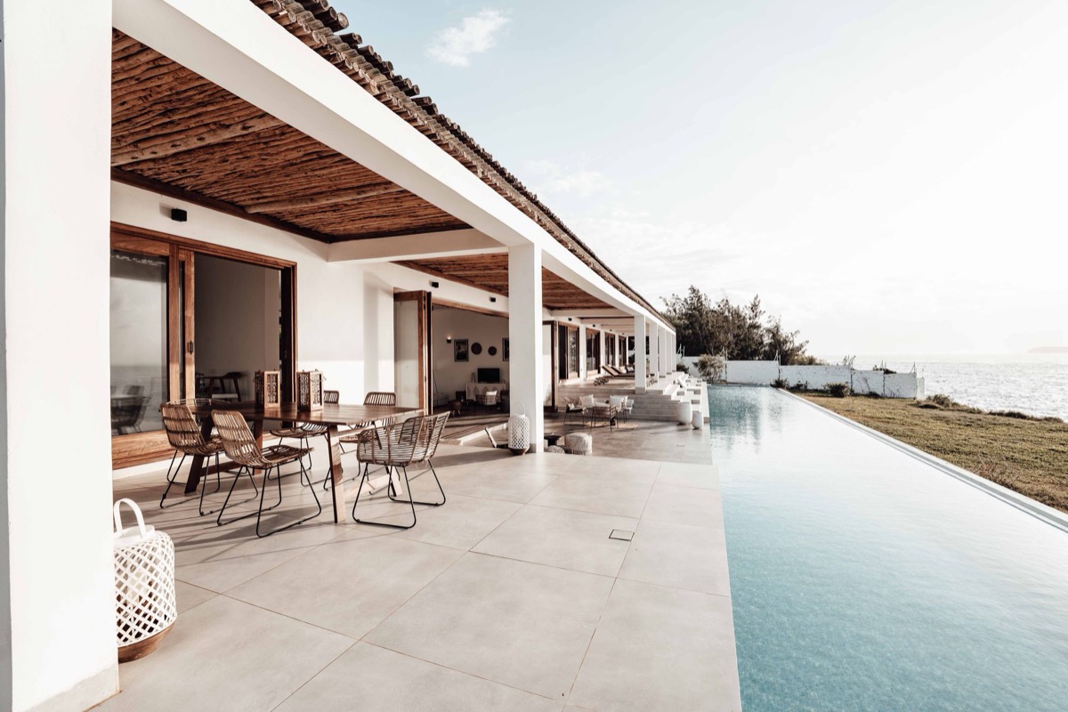 A low-rise waterfront villa with an infinity pool facing the sea